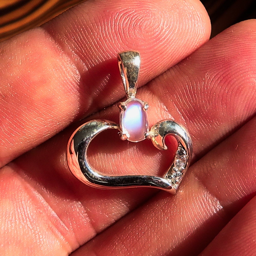 A beautiful Moonstone Pendant set in 925 sterling silver, featuring an oval moonstone surrounded by cubic zirconias, showcasing its elegant heart shape.